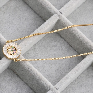 Macro view of gold plated sunburst pendant with colorful zircon stones in a velvet box