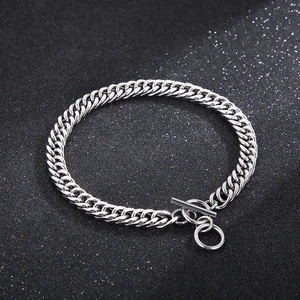 Detailed close-up of silver Cuban link chain with OT clasp over dark textured background