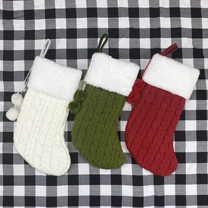 Trois chaussettes de Noël en maille torsadée blanche, verte et rouge avec fourrure