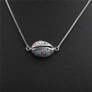 Copper shell pendant necklace with colorful cubic zirconia on black leather background