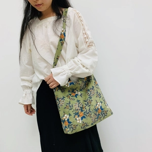 Vintage green corduroy tote bag with yellow floral pattern shown on a model
