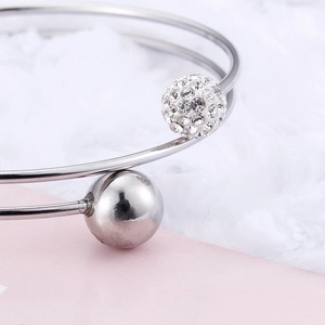 Elegant silver titanium steel open bangle with crystal pavé ball on plush background