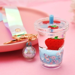 Close-up of strawberry milk tea keychain with flowing glitter and iridescent strap