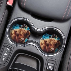 Detailed view of round Highland Cow coasters with blue turquoise texture in a car holder
