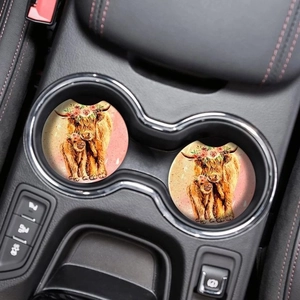 Car cup holder featuring two wooden coasters with highland cow watercolor art in vehicle