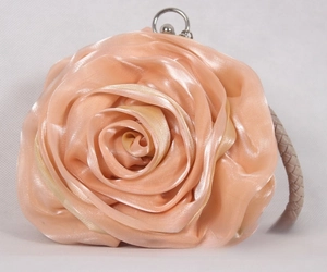 Macro shot of 3D satin rose flower clutch with silver clasp and braided strap detail