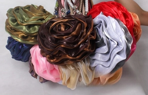 Detailed close-up of multi-colored satin silk 3D floral handbags with woven handles