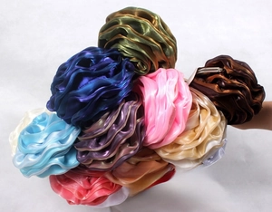 Macro view of assorted satin rose evening bags with multi-layered floral fabric textures