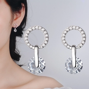 Macro shot of silver round zircon earrings with large sparkling crystal drop details