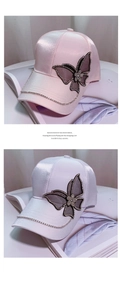 Detail of pink satin baseball cap featuring mesh butterfly and crystal chain fringe