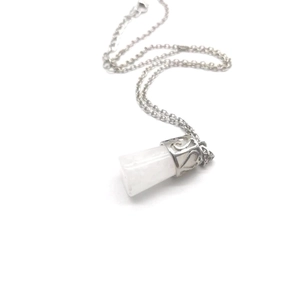 Macro detail of white crystal pillar necklace with ornate silver hollow pattern