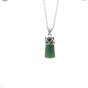 Macro detail of green crystal pendant with silver heart pattern bail and fine chain