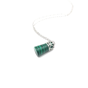Macro view of malachite cylinder pendant with ornate silver filigree geometric pattern