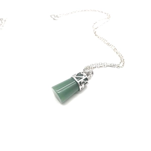 Detail of dark green cylindrical stone pendant with ornate silver hollow cap on O-chain