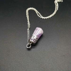 Close-up of a natural amethyst cylinder pendant with retro silver engraved metal cap