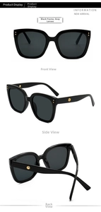 Detail view of large square black sunglasses with grey lenses and gold metal accents
