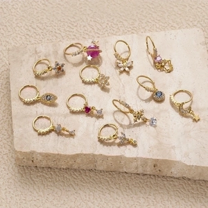 Golden hoop earrings set with colorful zircon charms including stars, moons and evil eyes