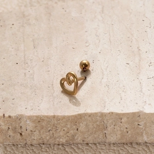 Gold stainless steel heart stud earring with screw ball back on stone surface