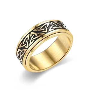 Rotating stainless steel Celtic knot ring in black and gold finish on white background