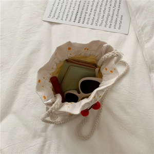 Top view of white floral canvas bucket bag showing capacity for wallet and sunglasses
