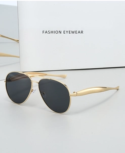 Close-up of golden metal aviator sunglasses with black lenses and white packaging