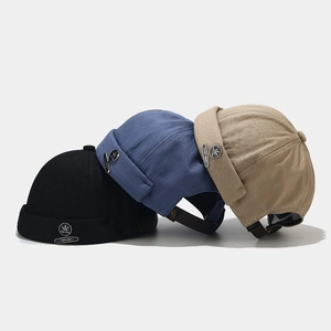 Classic brimless docker hats in black, navy and khaki with vintage metal logo emblems
