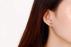 Close-up of a silver scorpion earring worn by a model showcasing creative metal design