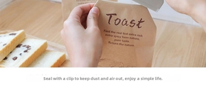 Weißer Kunststoff-Verschlussclip für Lebensmittel an einer Papiertüte mit Toastbrot