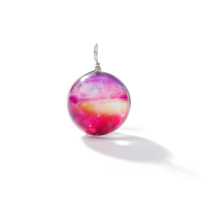 Macro view of a galaxy nebula glass ball pendant with silver wire wrap craftsmanship