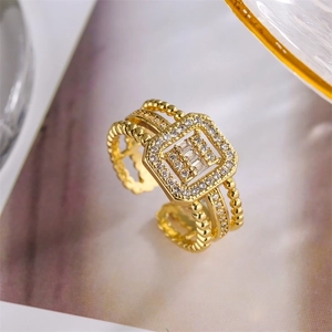 Macro view of gold plated three-row ring with rectangular stones and zircons