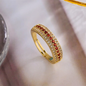 Detailed macro shot of gold-plated adjustable ring with red and white zircon stones