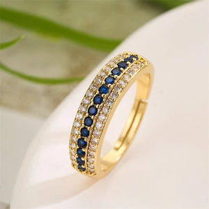 Macro detail of gold open ring with navy blue gems and white crystal pavé setting