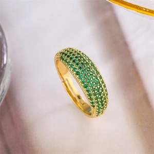 Macro shot of gold-plated open ring with micro-paved green zircon gemstones