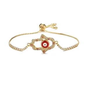 Adjustable gold Hamsa Hand bracelet with red Evil Eye and micro-paved diamonds on white background