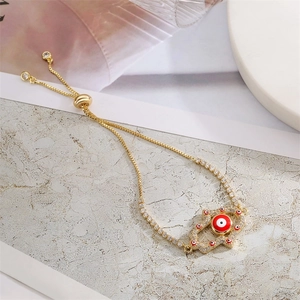 Golden Hamsa hand bracelet with evil eye and zircons on a stylish textured background