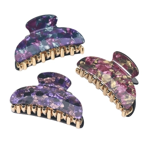 Three acrylic floral hair claws in purple, blue and pink with gold metal teeth