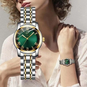 Detailed macro view of the green watch dial with gold Roman numerals and calendar display