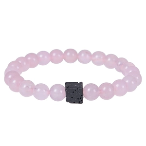 Close-up of pink translucent beads and a black square lava stone on an elastic bracelet