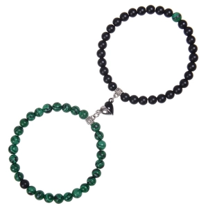 Close-up of magnetic heart clasp connecting green and black natural stone bracelets
