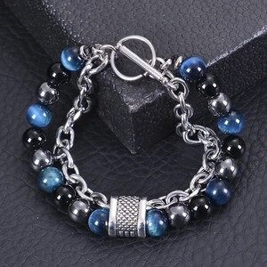 Detail of men's beaded bracelet with blue cat eye stone on black leather display