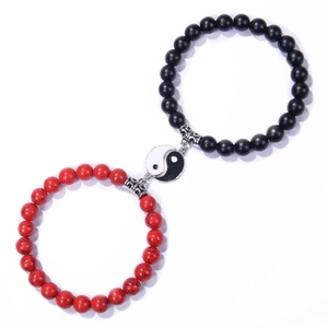 Macro detail of Yin Yang couple beaded bracelets with matte black and white marble stone beads
