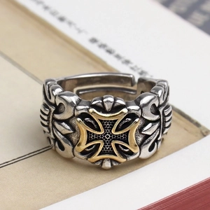 Vintage retro cross ring with gold and silver metal engraving on aged book pages