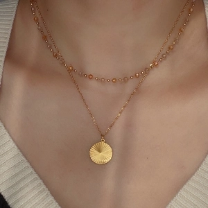 Double-layered 18k gold plated titanium necklace with sunburst pendant and amber beads