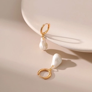 Elegant gold baroque pearl drop earrings displayed on minimalist ceramic tray aesthetic