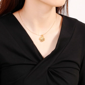 Elegant gold clover necklace set with cutout four-leaf pendant worn by a model