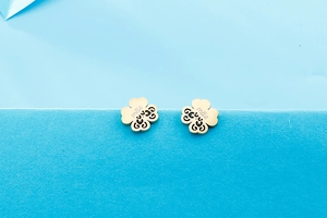 Detailed view of golden clover stud earrings with mother engraving and floral texture
