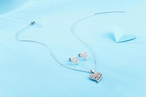 Vue détaillée du parure bijoux cœur argenté avec pendentif et boucles d'oreilles évidées