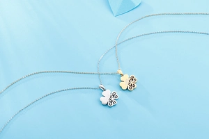 Detailed close-up of gold and silver four-leaf clover necklaces with mae engraving