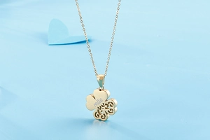 Detail of gold four-leaf clover pendant with mae engraving for Mother's Day