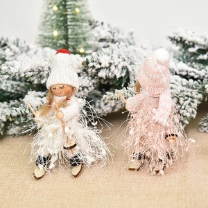 Christmas plush ski dolls ornaments with knit and faux fur textures on snowy background